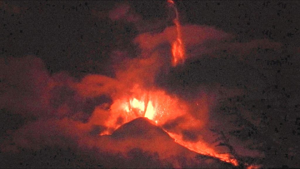Fontane di lava al culmine del parossismo, ore 00:40 del 23 febbraio 2021 La fontana più alta, emessa dalle bocche orientali del Cratere di Sud-Est, raggiunge un’altezza di oltre 1500 m. Il cono del Cratere di Sud-Est, alto circa 300 m, dà la scala. Vista da Tremestieri Etneo, versante sud dell’Etna.