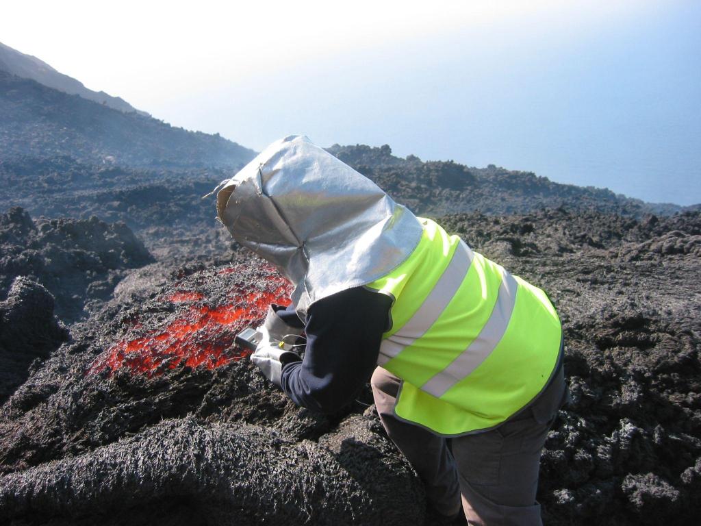 Figura - Campionamento della lava e misura della temperatura (fotografia di Piergiorgio Scarlato, 14 aprile 2003).