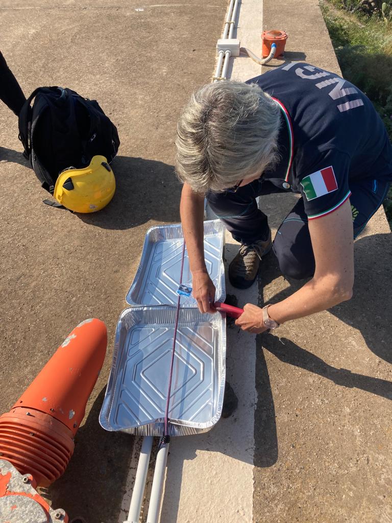 Figura 7 - Predisposizione dei contenitori per la raccolta di cenere nell’area dell’elipista di Ginostra - 25 maggio 2023.