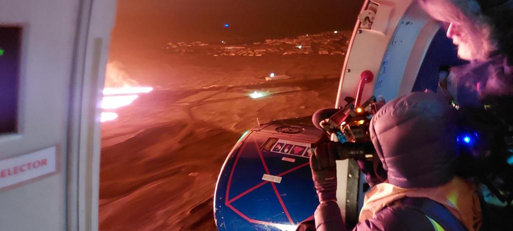 Figura 1 - Fotografia scattata a bordo del velivolo della Guardia Costiera islandese il 14 gennaio 2024. Si vede la nuova frattura con le luci di Grindavík in lontananza. Fonte dell’immagine: Icelandic Meteorological Office. https://en.vedur.is/about-imo/news/a-seismic-swarm-started-north-of-grindavik-last-night.